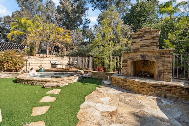 view of yard with a patio, an outdoor stone fireplace, and an in ground hot tub