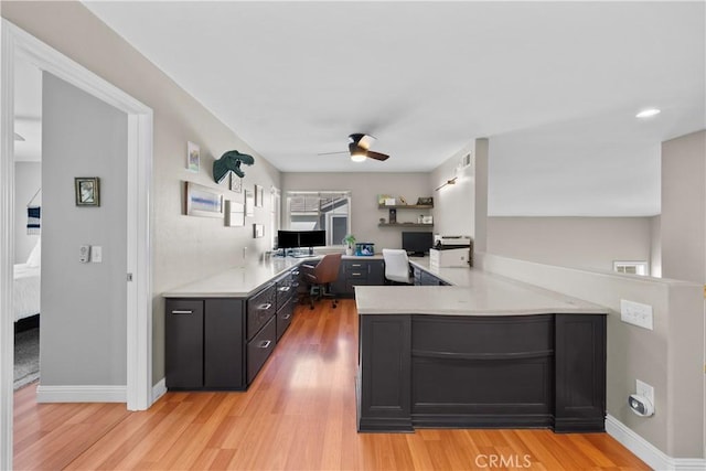 office with ceiling fan, built in desk, and light hardwood / wood-style floors