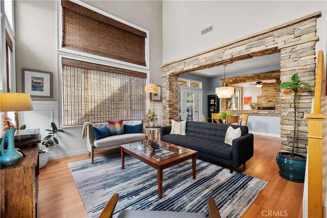 living room with a high ceiling, wood-type flooring, and french doors