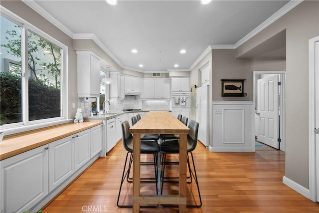 kitchen featuring wood counters, ornamental molding, and white cabinets