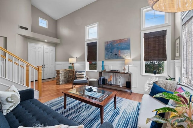 living room featuring high vaulted ceiling, a healthy amount of sunlight, and hardwood / wood-style floors