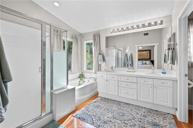 bathroom with lofted ceiling, plus walk in shower, wood-type flooring, and vanity