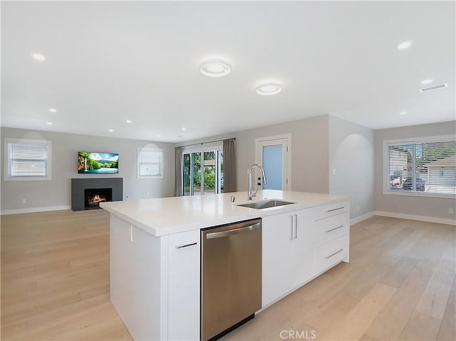 kitchen featuring a kitchen island with sink, sink, white cabinetry, and dishwasher