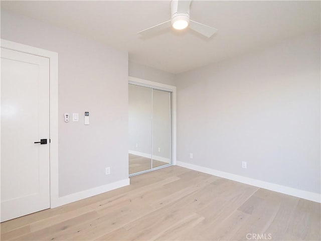 unfurnished bedroom featuring a closet, ceiling fan, and light wood-type flooring