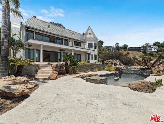 back of property with a balcony