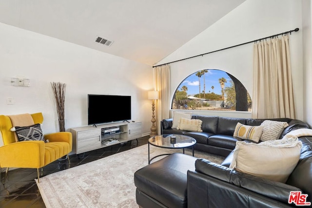 living room with dark tile patterned floors and lofted ceiling