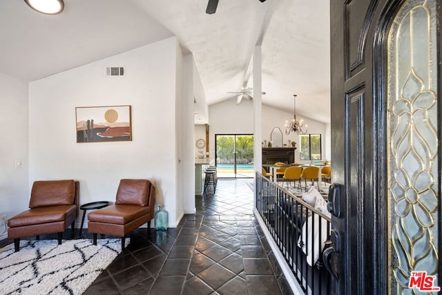 interior space with an inviting chandelier, lofted ceiling, and dark tile patterned flooring