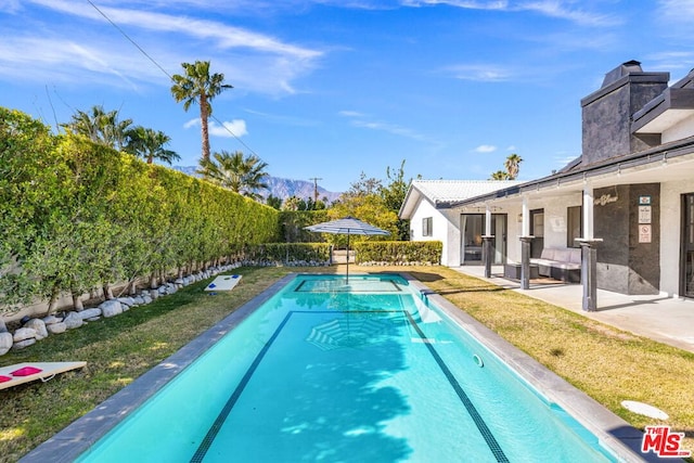 view of swimming pool featuring a yard and a patio