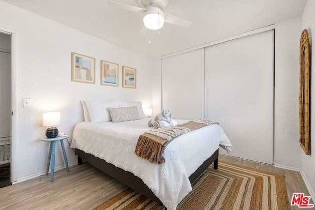 bedroom featuring ceiling fan, light hardwood / wood-style floors, and a closet