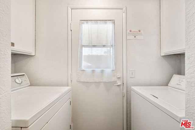 washroom featuring cabinets and separate washer and dryer