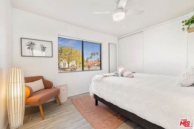 bedroom featuring ceiling fan, a closet, and light hardwood / wood-style flooring