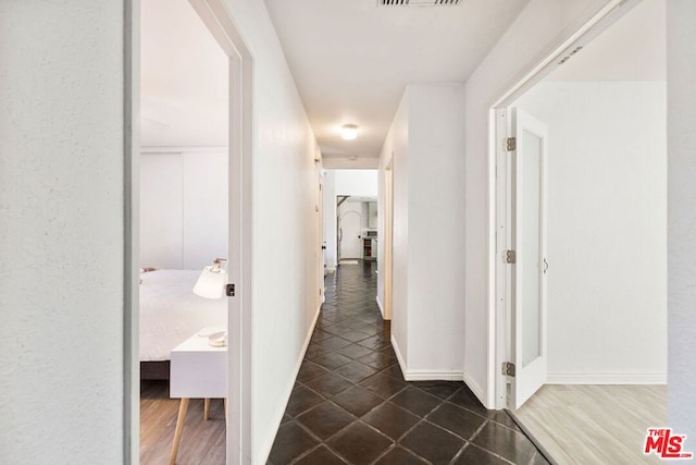 hall with dark tile patterned flooring