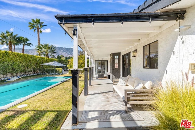 view of swimming pool with a mountain view, outdoor lounge area, and a patio area