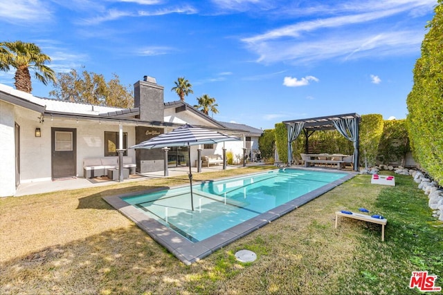 view of pool with a yard, a pergola, and a patio