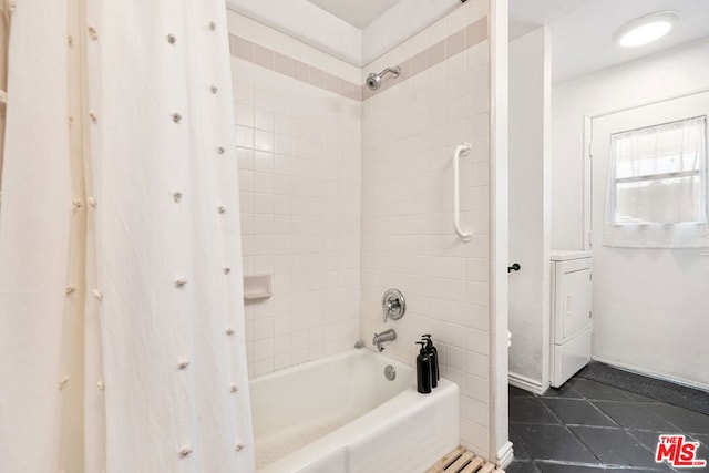 bathroom with tiled shower / bath combo, tile patterned flooring, and washer / clothes dryer