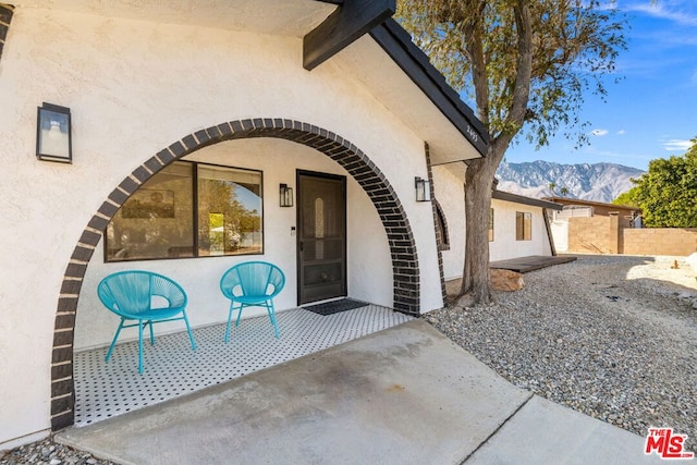 entrance to property featuring a mountain view and a patio