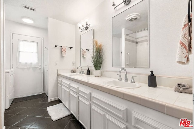 bathroom with vanity, tile patterned flooring, and a shower