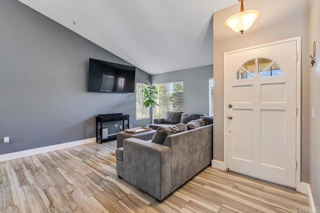 entryway featuring light wood-type flooring, lofted ceiling, and baseboards