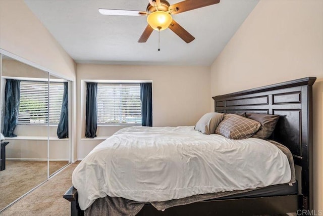 bedroom featuring vaulted ceiling, ceiling fan, light carpet, and a closet