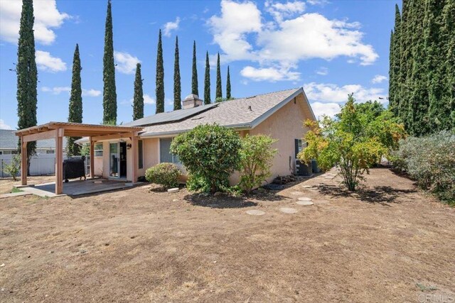 back of house with a patio and solar panels