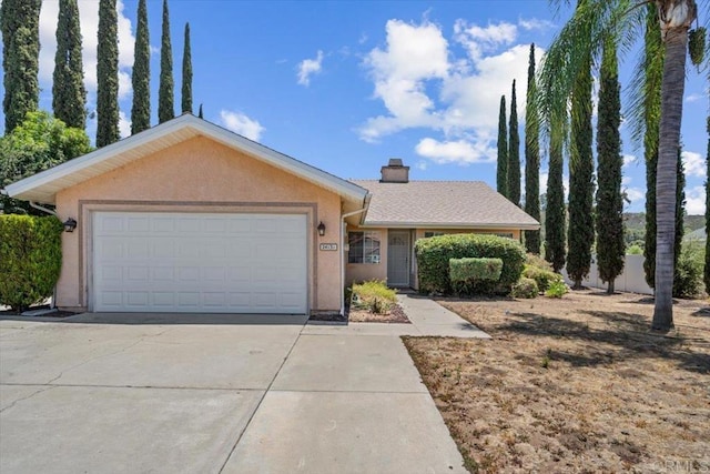 single story home featuring stucco siding, driveway, a chimney, and a garage