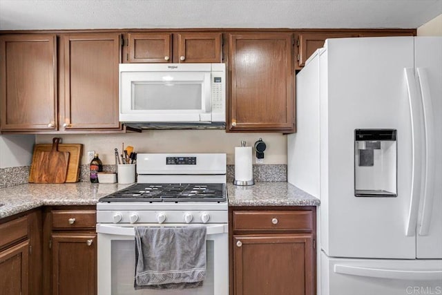 kitchen with brown cabinets and white appliances