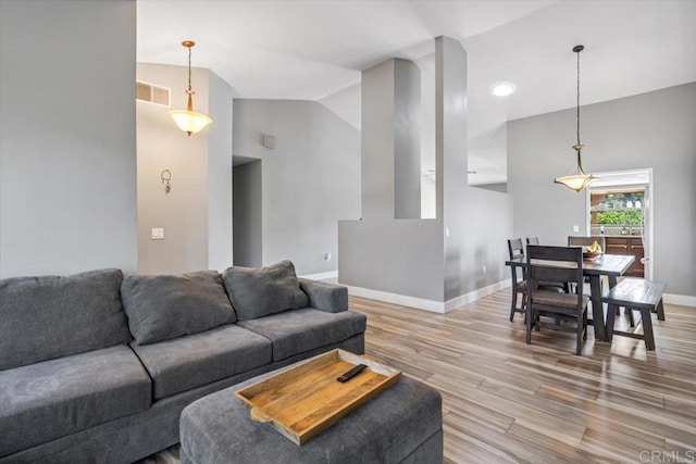 living room featuring lofted ceiling and hardwood / wood-style floors