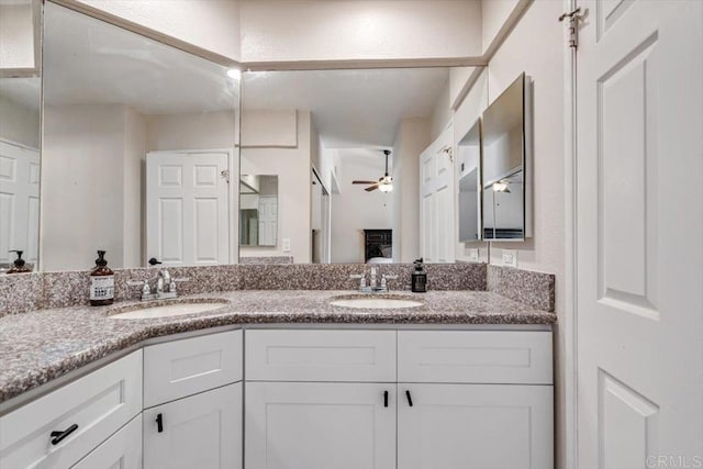 ensuite bathroom with ensuite bath, double vanity, a ceiling fan, and a sink