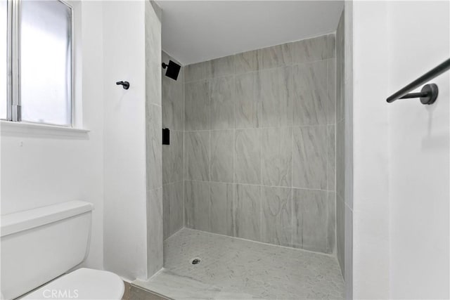 bathroom with toilet and tiled shower