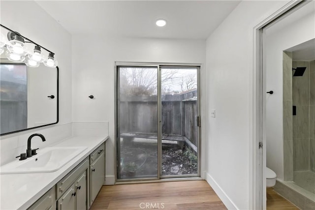 bathroom with vanity, hardwood / wood-style floors, toilet, and walk in shower