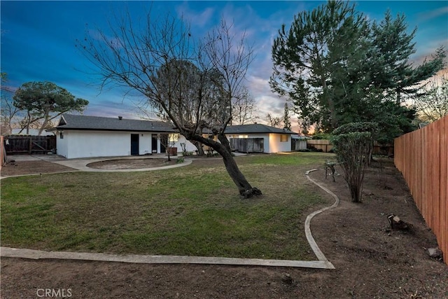 ranch-style house with a patio area and a lawn