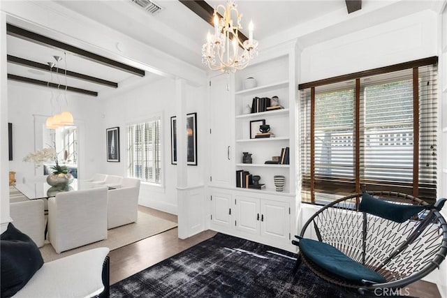 living room with dark hardwood / wood-style flooring, built in shelves, beamed ceiling, and an inviting chandelier