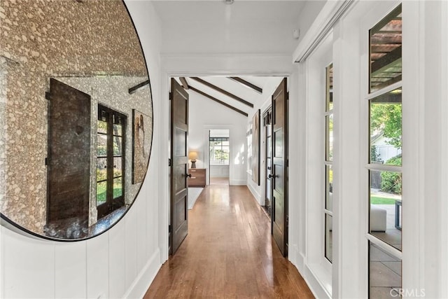 corridor with lofted ceiling with beams and wood-type flooring