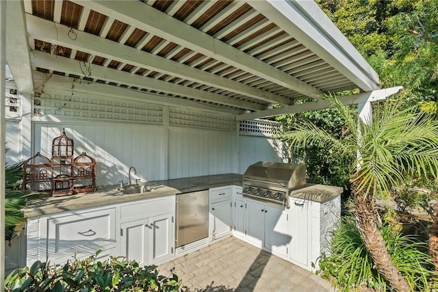 view of patio with an outdoor kitchen, a grill, and sink