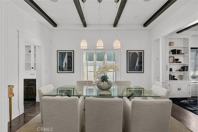 dining area featuring dark hardwood / wood-style floors, beam ceiling, and built in shelves