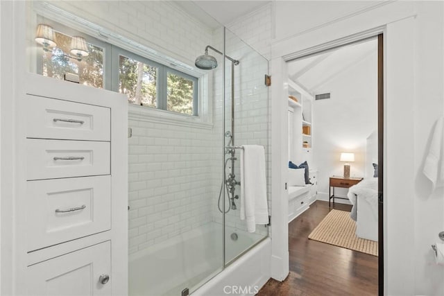 bathroom featuring wood-type flooring and shower / bath combination with glass door