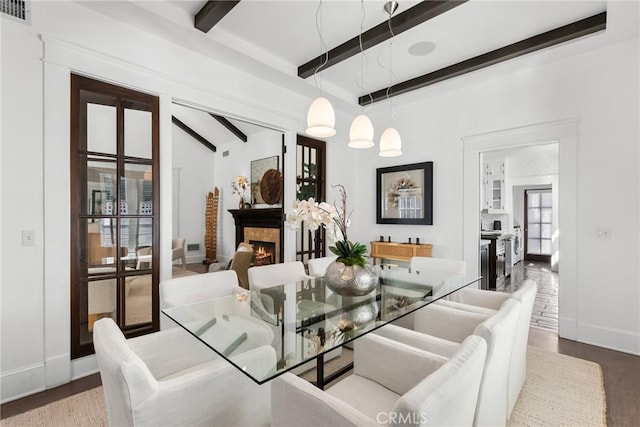 dining room with beamed ceiling and hardwood / wood-style flooring