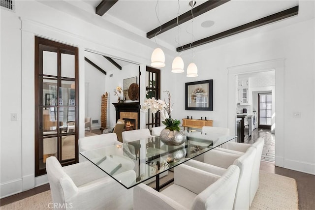 14115 Greenleaf St, Sherman Oaks, CA 91423 - dining area featuring beam ceiling, baseboards, a lit fireplace, and wood finished floors