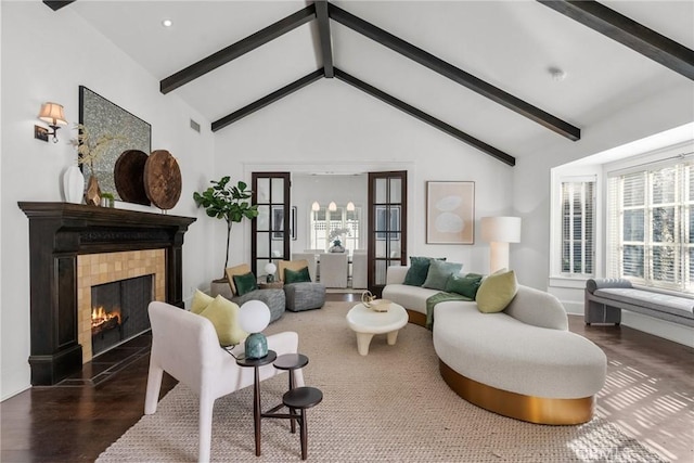 living room with dark hardwood / wood-style flooring, lofted ceiling with beams, and a tile fireplace