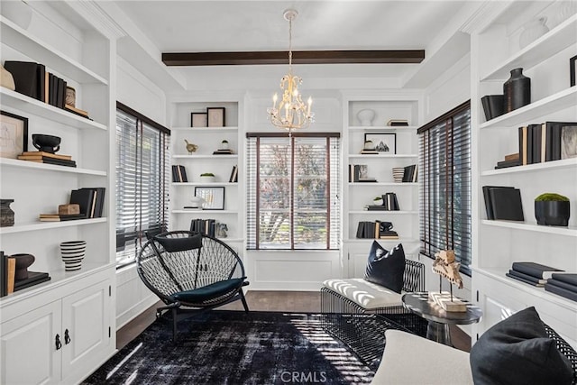 living area with dark wood-type flooring, a notable chandelier, beam ceiling, and built in shelves