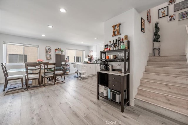 kitchen featuring white cabinets, dark brown cabinetry, and light hardwood / wood-style flooring