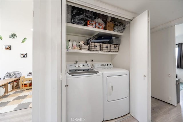 laundry room featuring separate washer and dryer and light wood-type flooring