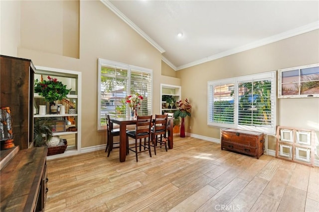 dining area with baseboards, high vaulted ceiling, wood finished floors, and crown molding