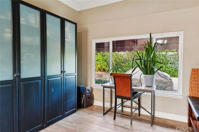 office area featuring light wood-style floors, crown molding, and baseboards