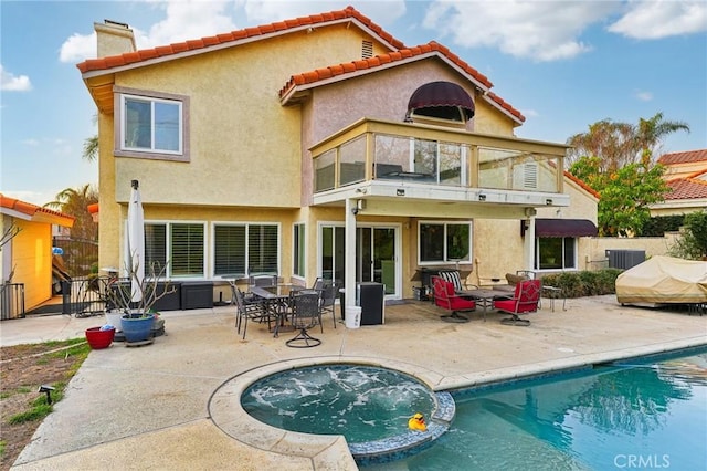 rear view of house featuring a patio, a chimney, an outdoor pool, and stucco siding