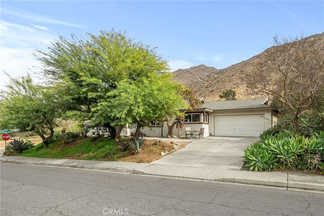 view of front of house featuring driveway, an attached garage, and a mountain view