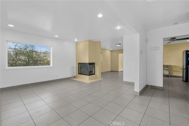 unfurnished living room featuring light tile patterned floors, ceiling fan, recessed lighting, a fireplace, and baseboards