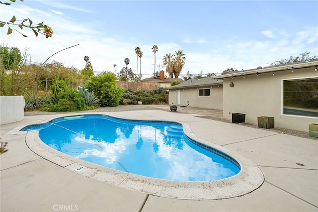 outdoor pool with a patio area and fence