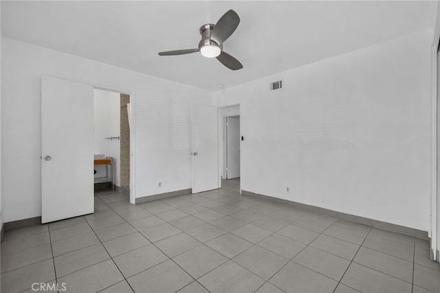 unfurnished bedroom with light tile patterned floors, baseboards, visible vents, and ceiling fan