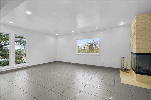 unfurnished living room featuring baseboards, recessed lighting, a fireplace, and tile patterned floors